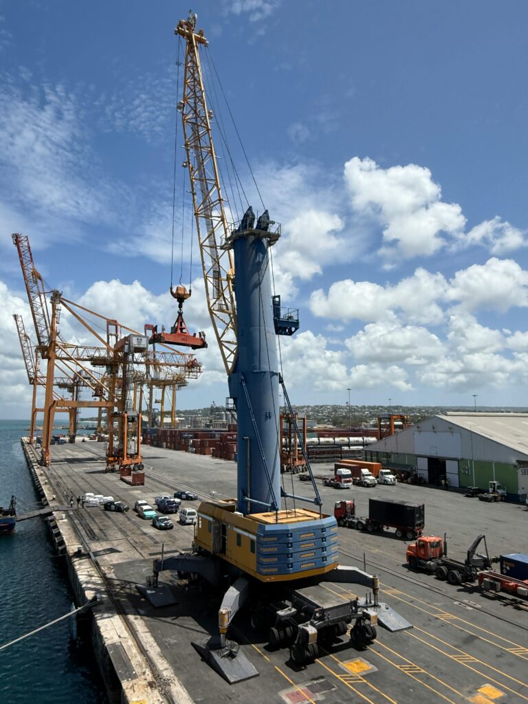 pexels photo 33564115 33564115 Large cargo cranes and a busy dockside in an industrial port on a sunny day.