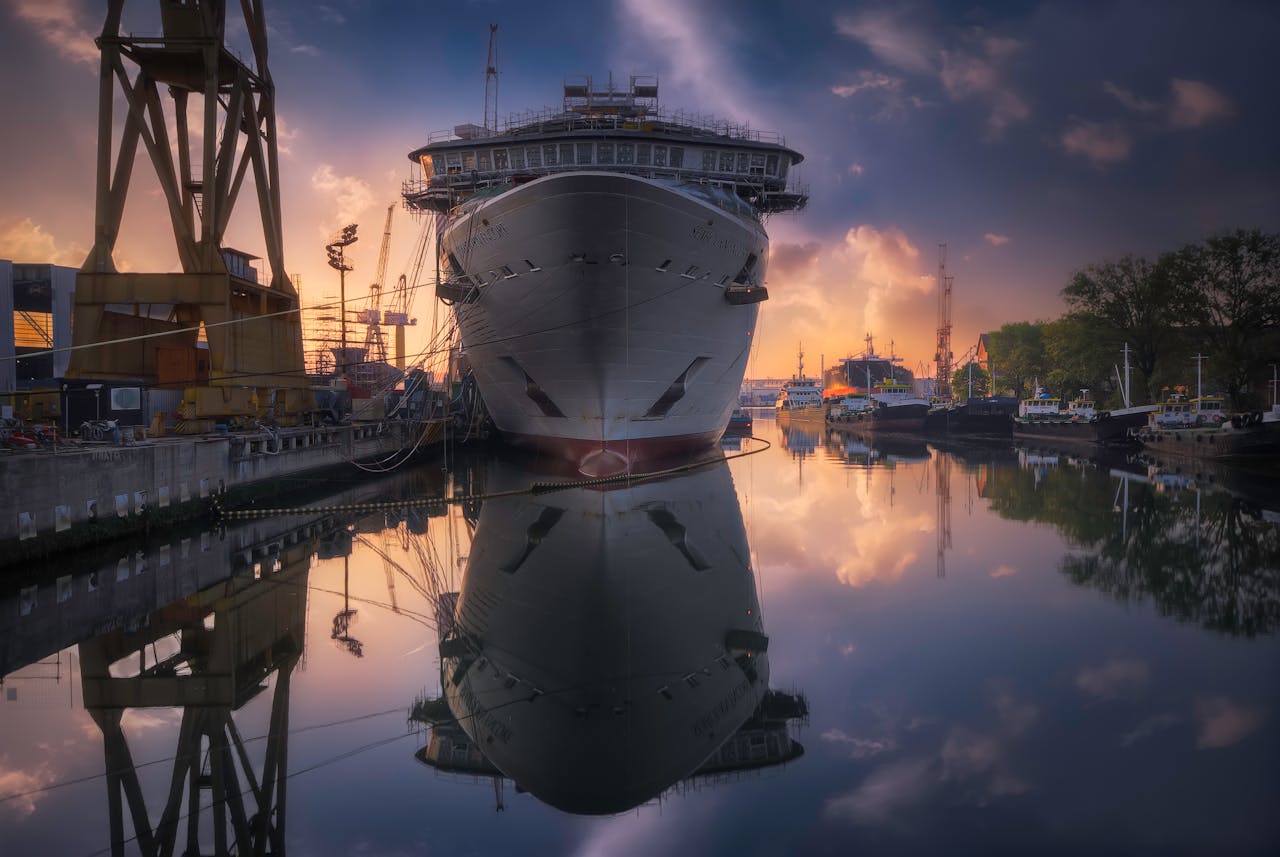 Dramatic sunrise over a ship docked in a Venetian harbor, reflections on calm water.