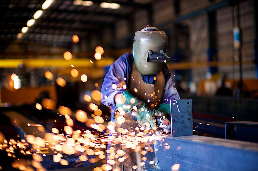 pexels photo 5362681 5362681 An industrial worker in a workshop welding metal with protective gear, creating vibrant sparks.